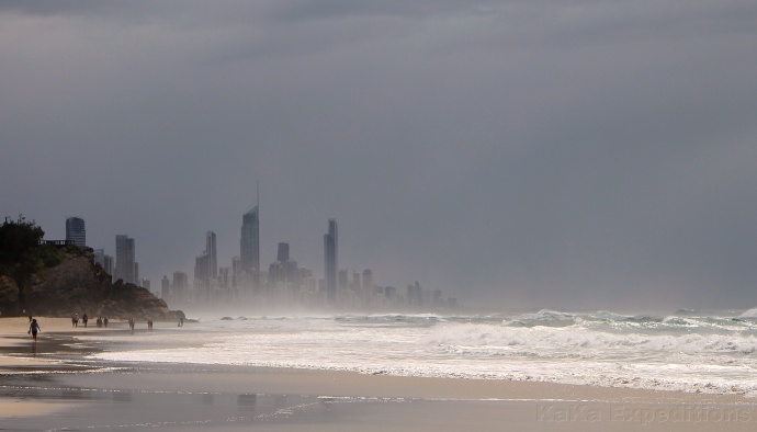 Mlžný opar nad krásnou písčitou pláží skrývá velké budovy blízkého města Gold Coast. Foto: KaKa Expedition