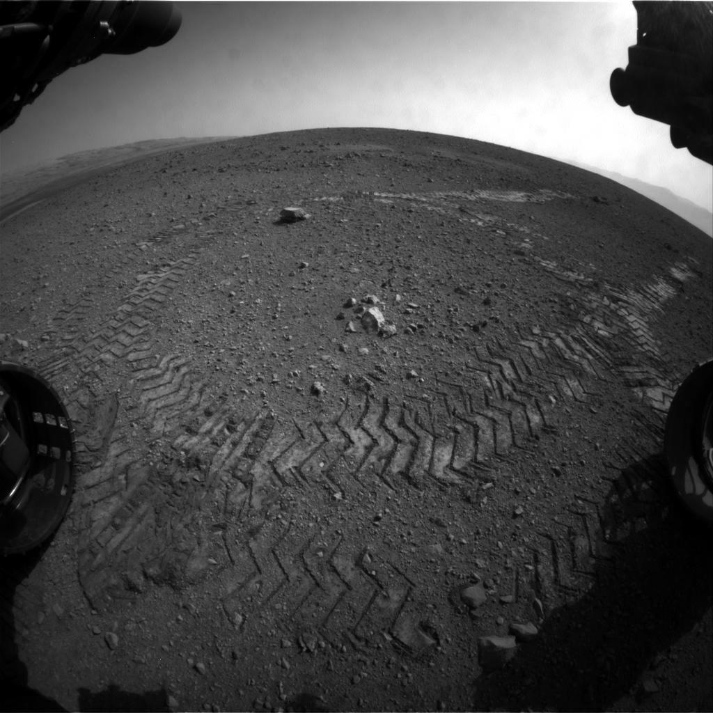 Stopy zanechané na povrchu Marsu. Snímek byl pořízen kamerou sloužící pro předcházení nebezpečí, která je vybavena objektivem typu rybí oko. Foto: NASA/JPL-Caltech.