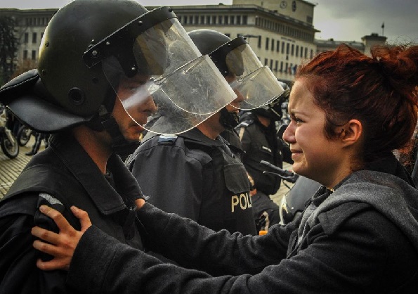 Těžkooděnec a protestující proti chudobě a korupci sdílí pláč - Sofie, Bulharsko 2013, zdroj: www.reddit.com.jpg