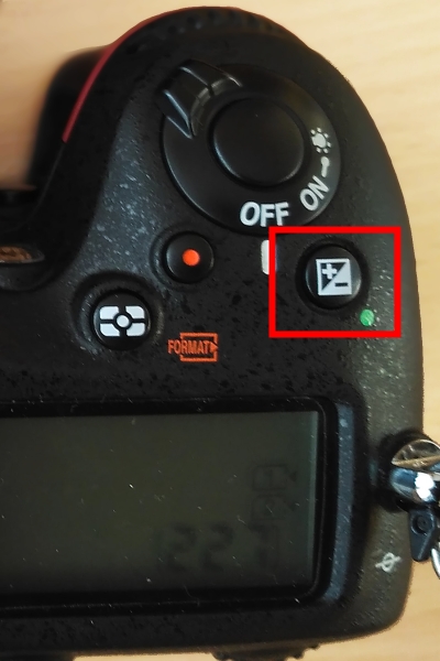 Tlačítko korekce expozice na digitální zrcadlovce Nikon D7200.