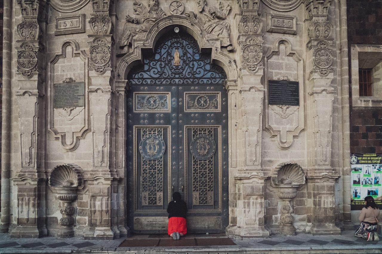 modlící se žena před dvěřmi kláštera, Mexico